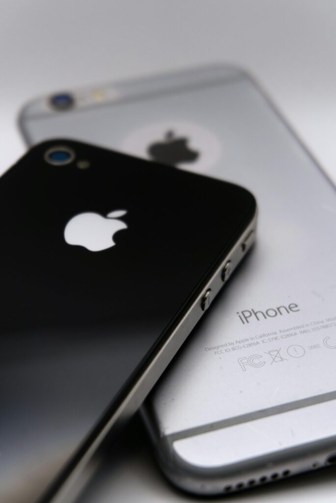 Detailed shot of two smartphones featuring the Apple logo, showcasing modern technology design.